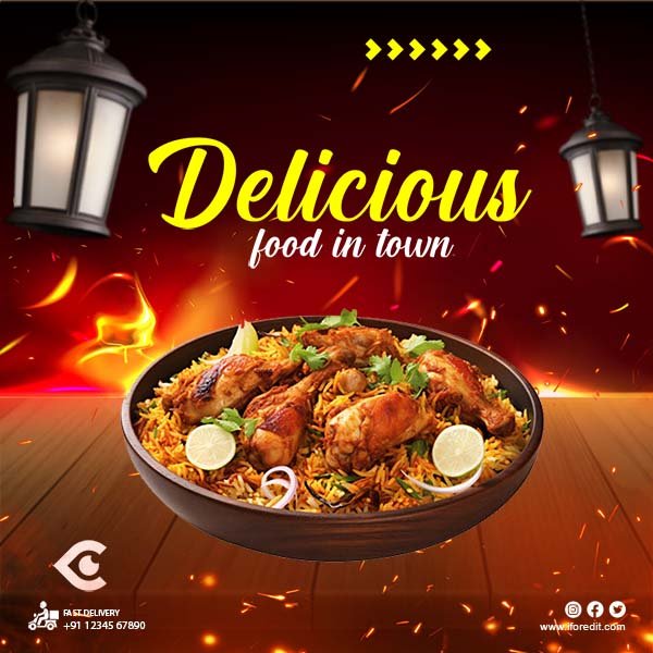 Spicy chicken biryani in a black bowl with lemon and garnish on a wooden table background